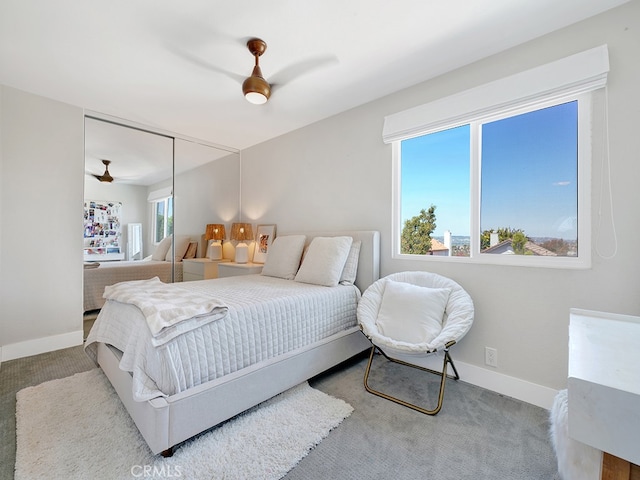 carpeted bedroom featuring ceiling fan and a closet