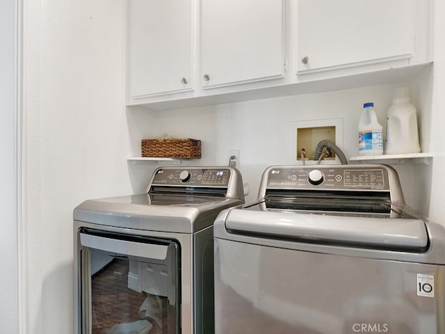 washroom with separate washer and dryer and cabinets