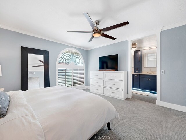 carpeted bedroom featuring ornamental molding, ensuite bath, ceiling fan, and sink