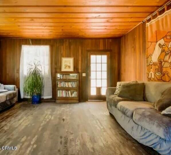 sitting room with wooden walls and hardwood / wood-style floors