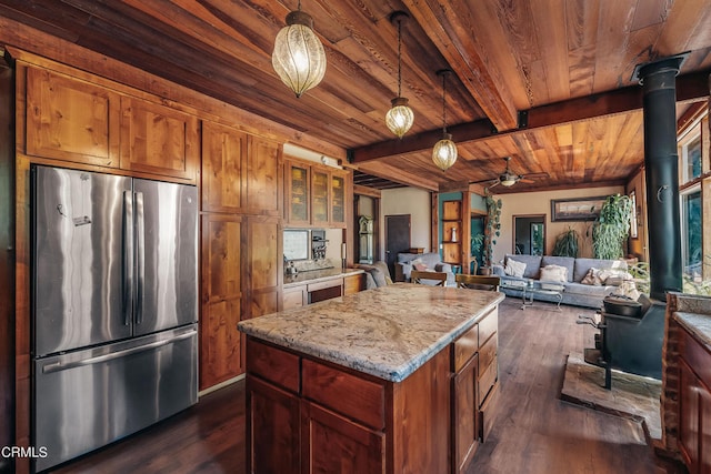 kitchen featuring pendant lighting, beamed ceiling, dark hardwood / wood-style floors, a kitchen island, and stainless steel fridge