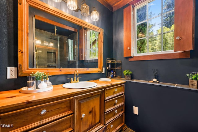 bathroom featuring vanity, a shower, and ornamental molding