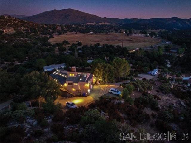 aerial view at dusk featuring a mountain view