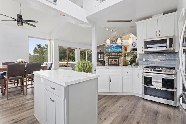 kitchen featuring pendant lighting, white cabinets, appliances with stainless steel finishes, backsplash, and ceiling fan