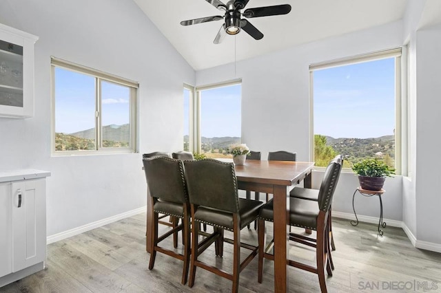 dining area featuring ceiling fan, plenty of natural light, a mountain view, and light hardwood / wood-style flooring