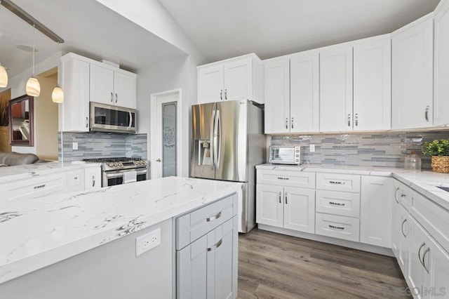 kitchen with white cabinets, backsplash, vaulted ceiling, and appliances with stainless steel finishes