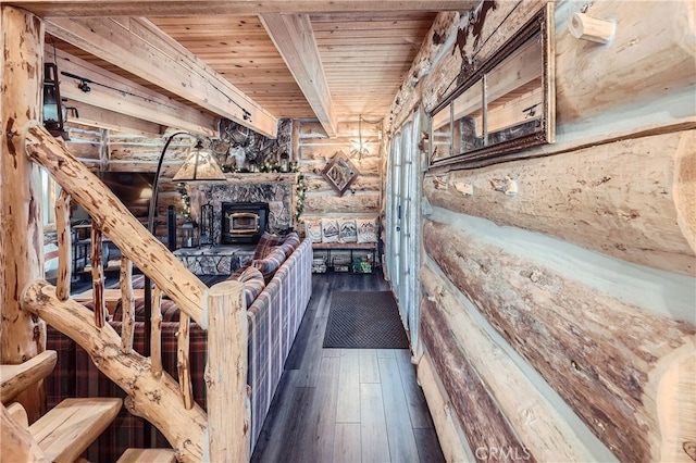 interior space featuring wood ceiling, log walls, dark hardwood / wood-style floors, and a wood stove