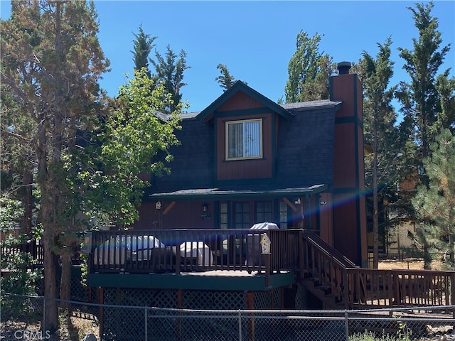 rear view of house featuring a wooden deck