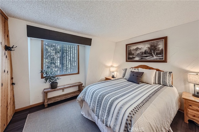 bedroom featuring a textured ceiling and dark hardwood / wood-style floors