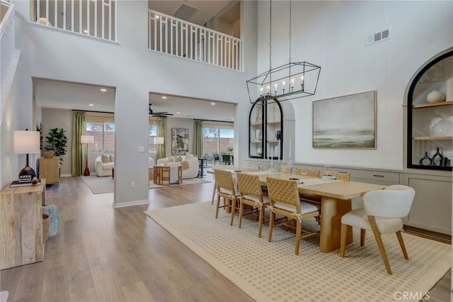 dining room with a wealth of natural light, light wood-type flooring, a chandelier, and visible vents