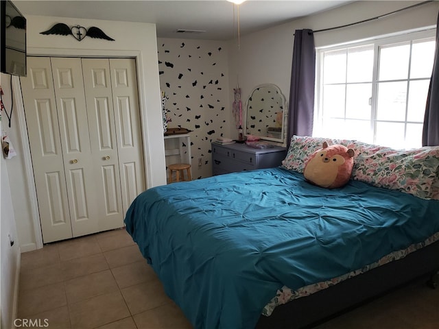 tiled bedroom with a closet