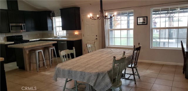 dining area featuring a notable chandelier, light tile patterned floors, and sink