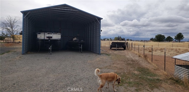 view of outdoor structure featuring a carport and a rural view