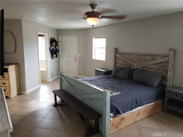 bedroom featuring ceiling fan, light tile patterned flooring, and ensuite bathroom