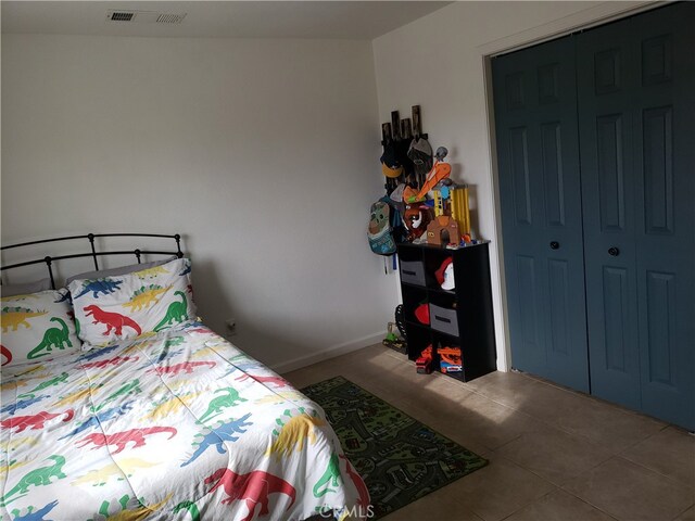 bedroom with a closet and tile patterned floors