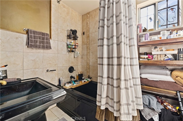 bathroom featuring walk in shower, tile walls, sink, and tile patterned floors