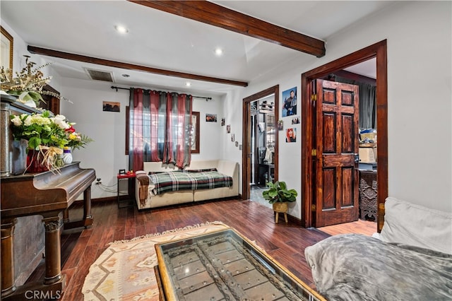 bedroom with beamed ceiling and dark hardwood / wood-style floors