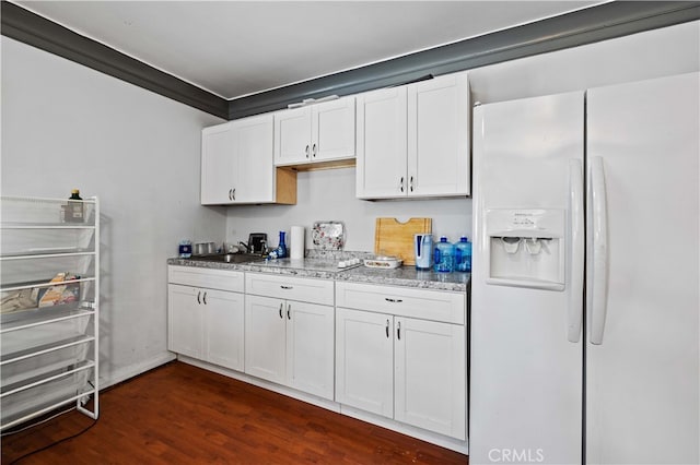 kitchen with white refrigerator with ice dispenser, dark hardwood / wood-style floors, sink, and white cabinetry