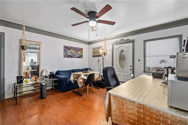 office area with ornamental molding, an AC wall unit, ceiling fan, and hardwood / wood-style flooring