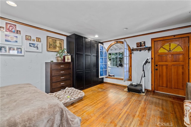 bedroom featuring ornamental molding and hardwood / wood-style flooring