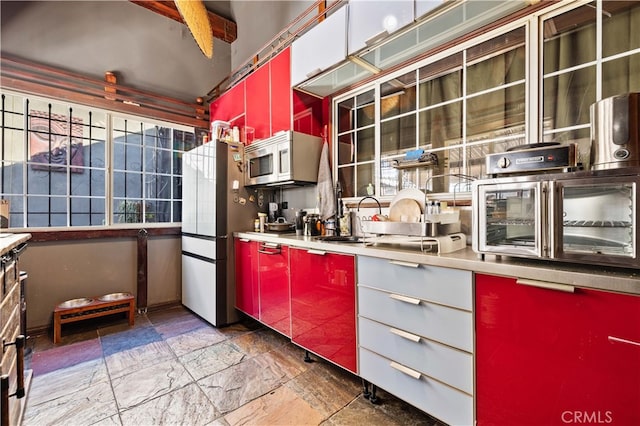 kitchen with beam ceiling, appliances with stainless steel finishes, and sink