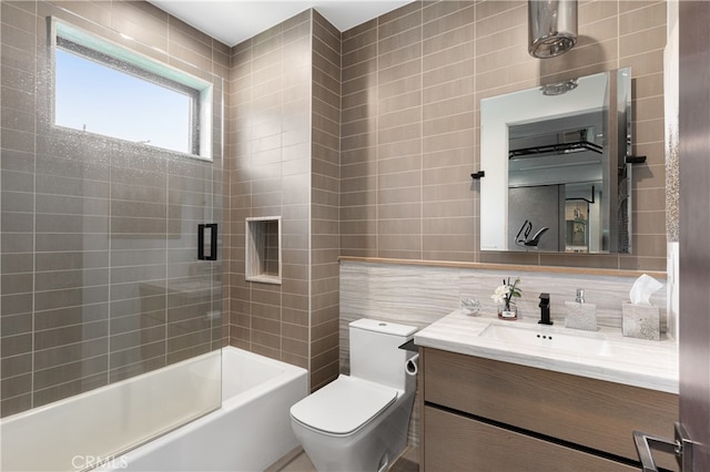 full bathroom with tile walls, tasteful backsplash, shower / bathing tub combination, vanity, and toilet