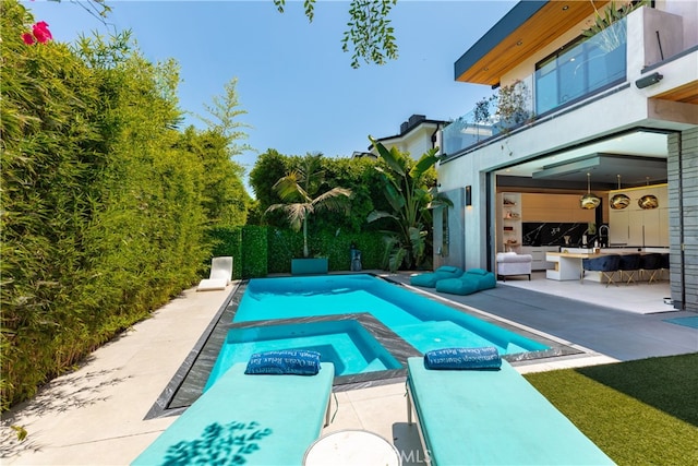 view of swimming pool with an in ground hot tub and a patio area