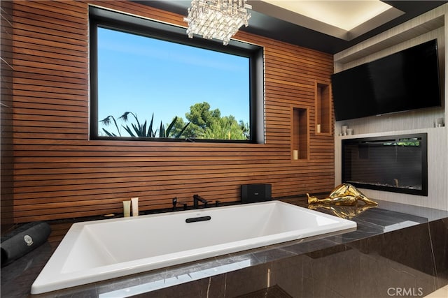 bathroom featuring tiled tub and wooden walls