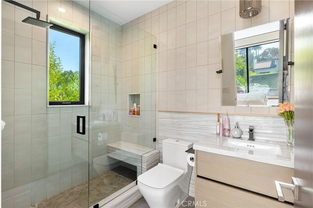 bathroom featuring tile walls, plenty of natural light, vanity, and toilet