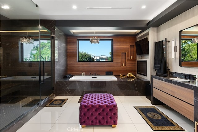 bathroom featuring plus walk in shower, an inviting chandelier, vanity, and tile patterned floors