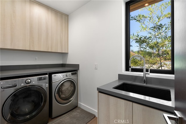 laundry room featuring cabinets, sink, and washing machine and clothes dryer