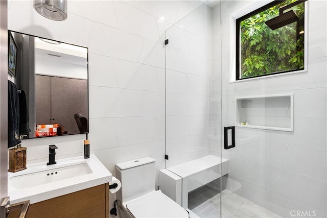 bathroom featuring walk in shower, tile walls, vanity, and toilet