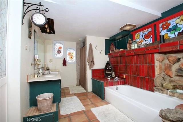 bathroom featuring a bathing tub, vanity, and tile patterned flooring