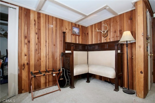 sitting room featuring light carpet and wood walls