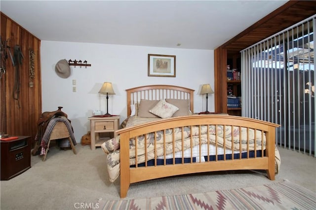 carpeted bedroom with wooden walls