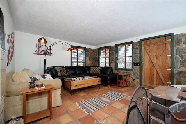 tiled living room featuring a barn door and a textured ceiling