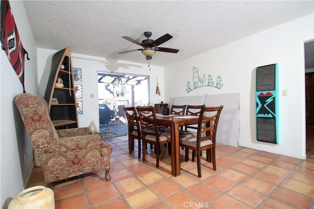 tiled dining area with ceiling fan and a textured ceiling