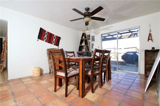 tiled dining room with a textured ceiling and ceiling fan