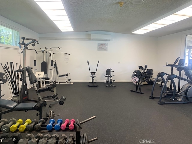 workout area with a textured ceiling and a wall unit AC