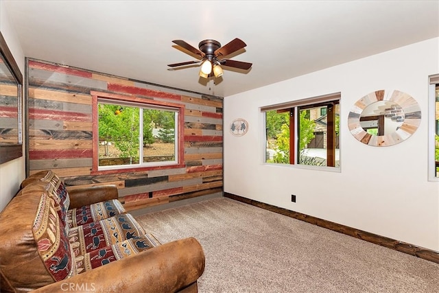 living area with carpet floors and ceiling fan