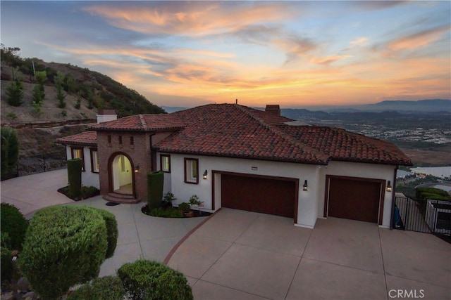 mediterranean / spanish-style home with a mountain view and a garage