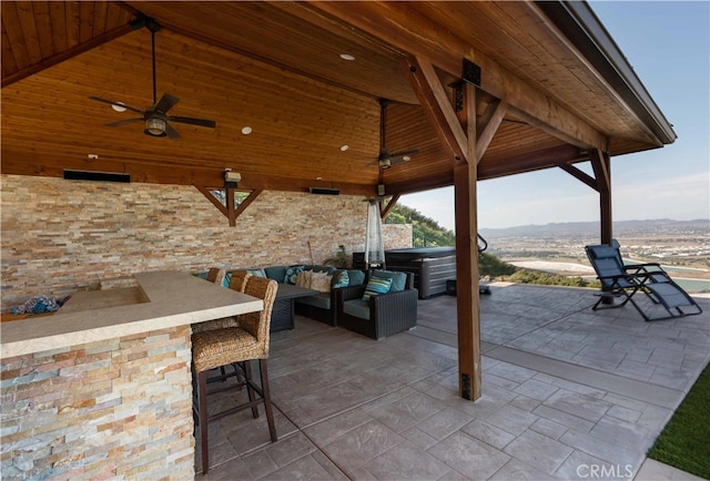 view of patio / terrace with outdoor lounge area, a mountain view, ceiling fan, a gazebo, and an outdoor bar