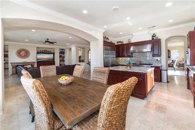 tiled dining area with crown molding and ceiling fan