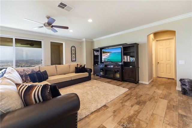 living room with ornamental molding, light hardwood / wood-style flooring, and ceiling fan