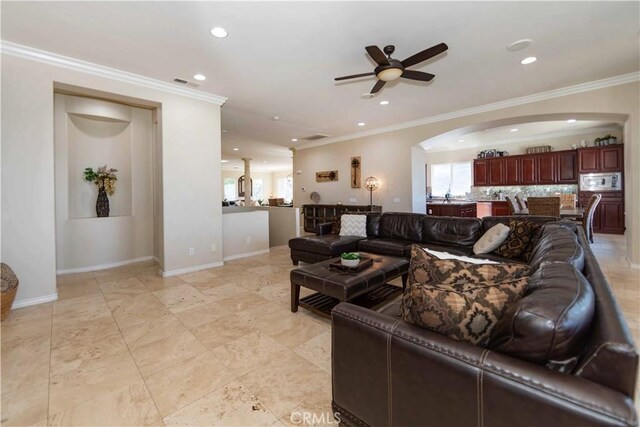 living room with ornamental molding and ceiling fan