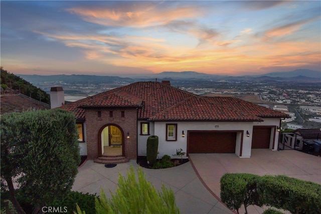 mediterranean / spanish-style house with a mountain view and a garage