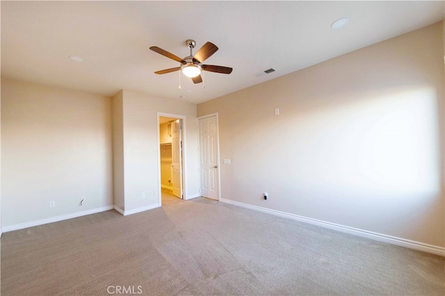 empty room with ceiling fan and light carpet