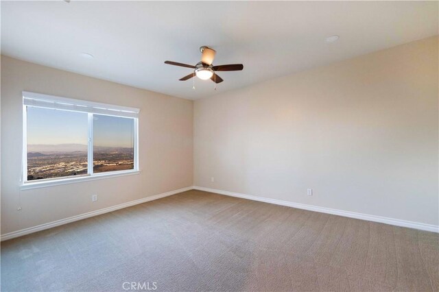 empty room featuring carpet floors and ceiling fan