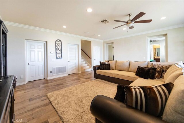 living room featuring crown molding, light wood-type flooring, and ceiling fan