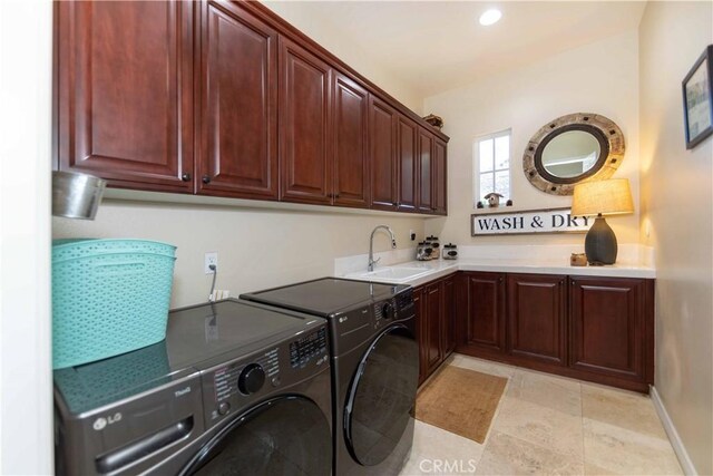 clothes washing area with cabinets, sink, and washing machine and clothes dryer